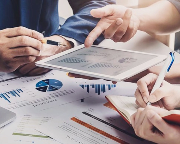 Drei Personen betrachten auf einem Tablet gemeinsam die Entwicklung von Anleihen