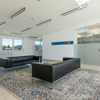 Innenansicht der BTV Bank Filiale Kirchbichl in der Europastraße 8 mit Ledersofas und hochwertigem Teppich auf Fliesenboden