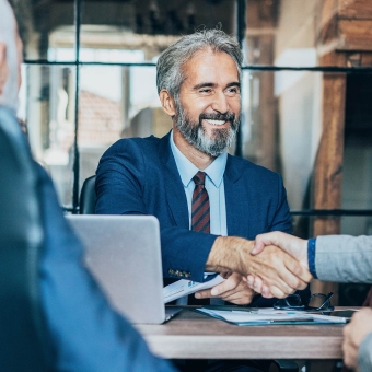 Businessmann schüttelt einer anderen Person die Hand