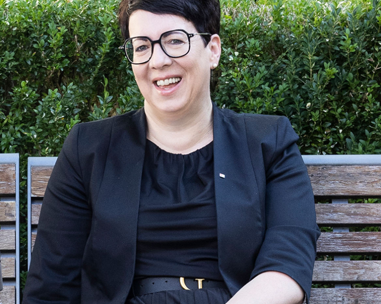 Eine Frau sitzt auf einer Parkbank