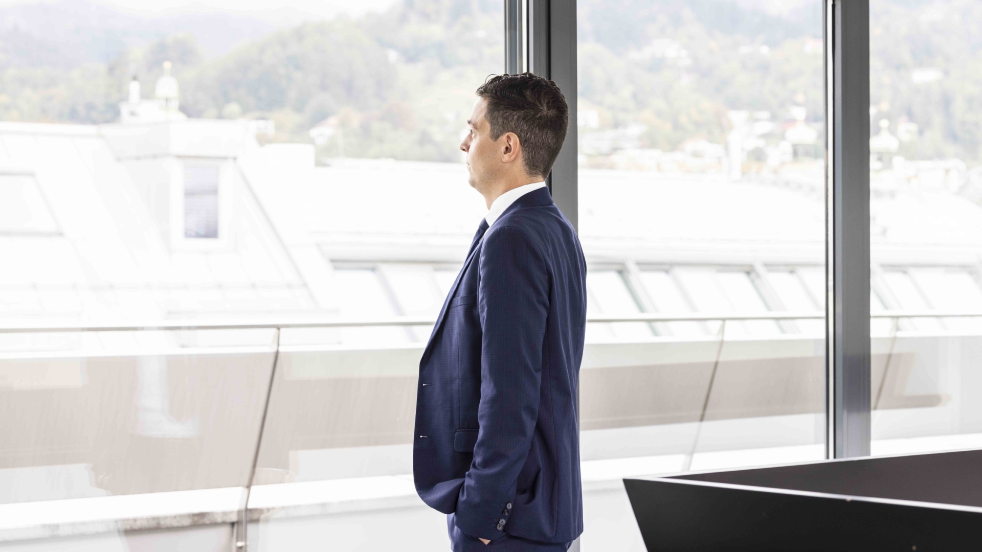 Ein Mann in einem blauen Anzug sieht in die Ferne