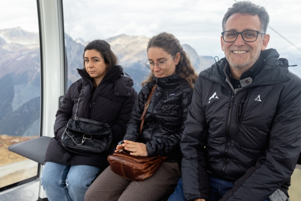 3 Personen sitzen in einem Skilift