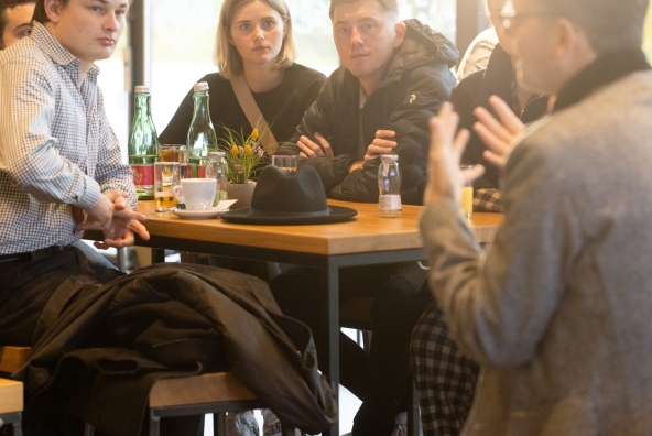 Eine Gruppe Personen sitzen an einem Stehtisch