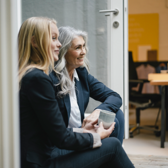 2 Frauen sitzen und sehen in die Ferne