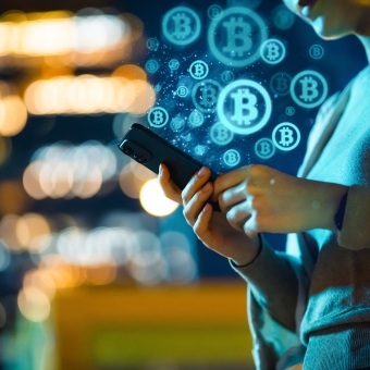 Frau lernt am Smartphone Kryptowährungen Grundlagen