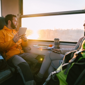 2 Personen reisen im Zug und schauen nach draußen
