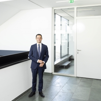 BTV Mitarbeiter Mario Scherl im eleganten Anzug im Stiegenhaus.