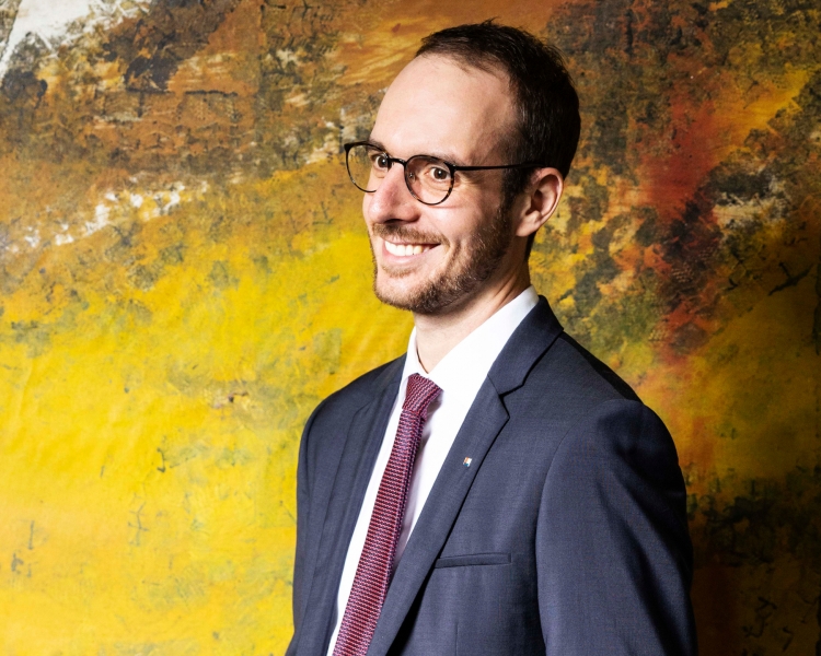 Foto Lukas Wahlbrink vor buntem Hintergrund.