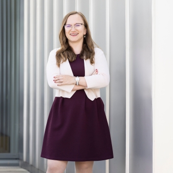 Frau mit verschränkten Armen vor grauem Hintergrund