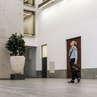Mann mit Hemd läuft in einer Bankfiliale herum.