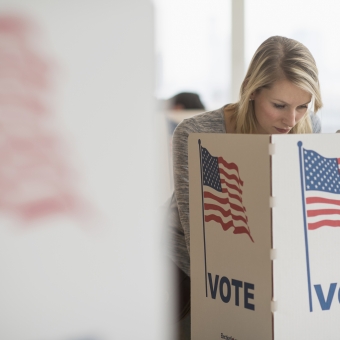 Frau steht bei Kabine bei der US-Wahl.