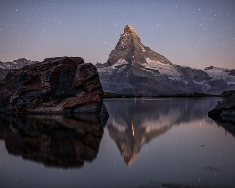 Ein See mit einem Berg im Hintergrund.