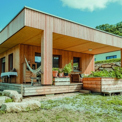 Kleines Holzhaus mit Terrasse und Garten davor