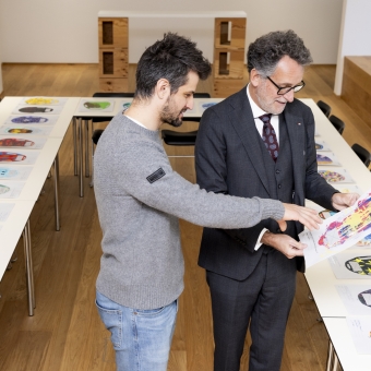 Zwei Männer sehen sich ein Plakat an.