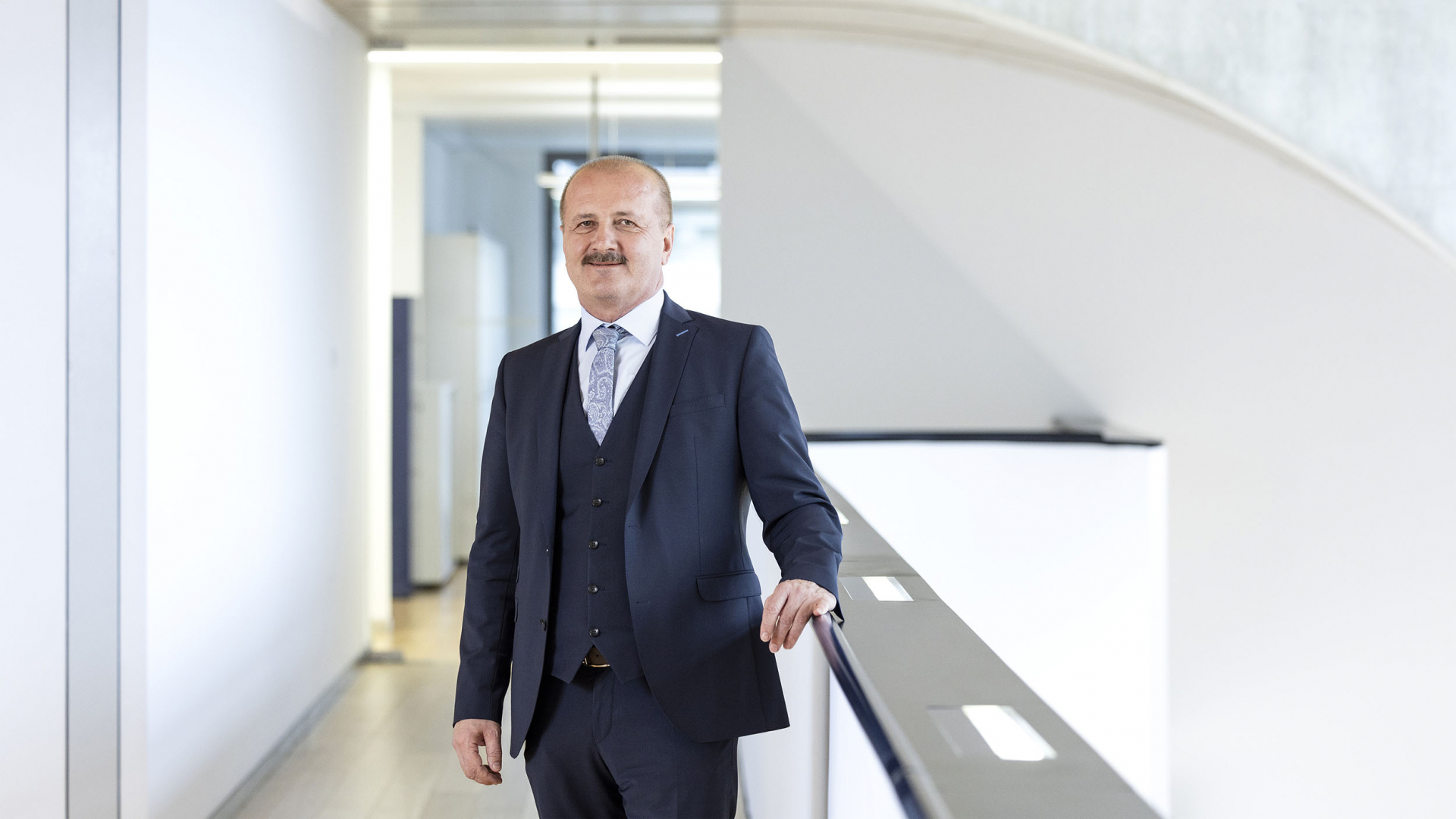 Ein Mann im blauen Anzug mit blauer Weste und Krawatte