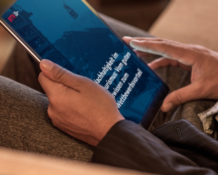 Hände halten ein Tablet in der Hand auf dem zu lesen ist: "Nachhaltigkeit im Tourismus: Vom guten Gewissen zum Wettbewerbsvorteil."