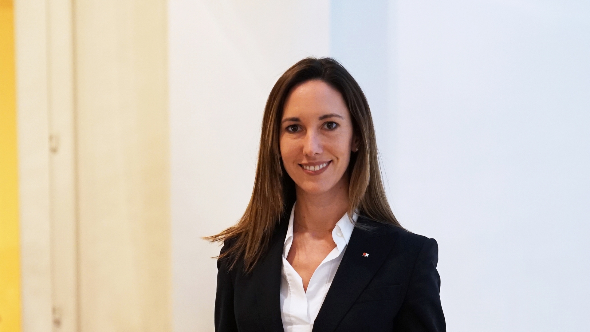 Eine Frau in einem Anzug lehnt sich an ein Geländer