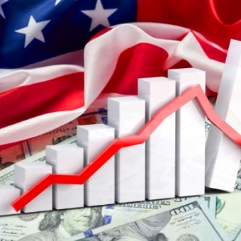 Balken und ein Graph auf Dollarnoten mit der US-Flagge im Hintergrund
