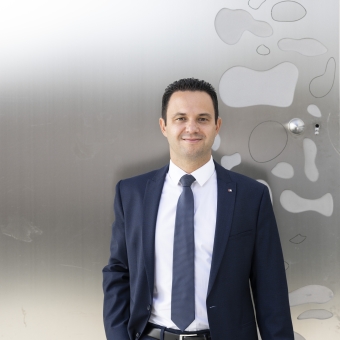 Ein Mann steht vor einem Gebäude und trägt einen blauen Anzug