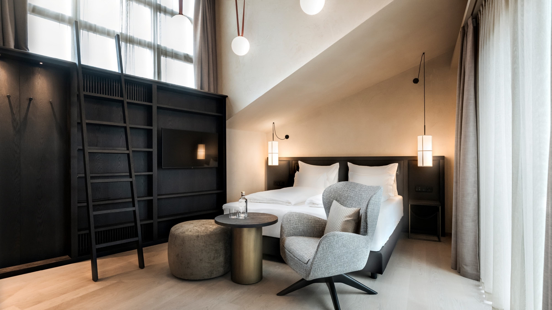 Schlafzimmer mit Doppelbett und einem Stuhl sowie Tisch und Hocker vor dem Bett