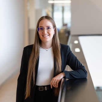 Eine Frau mit Brille steht in einer Bankfiliale