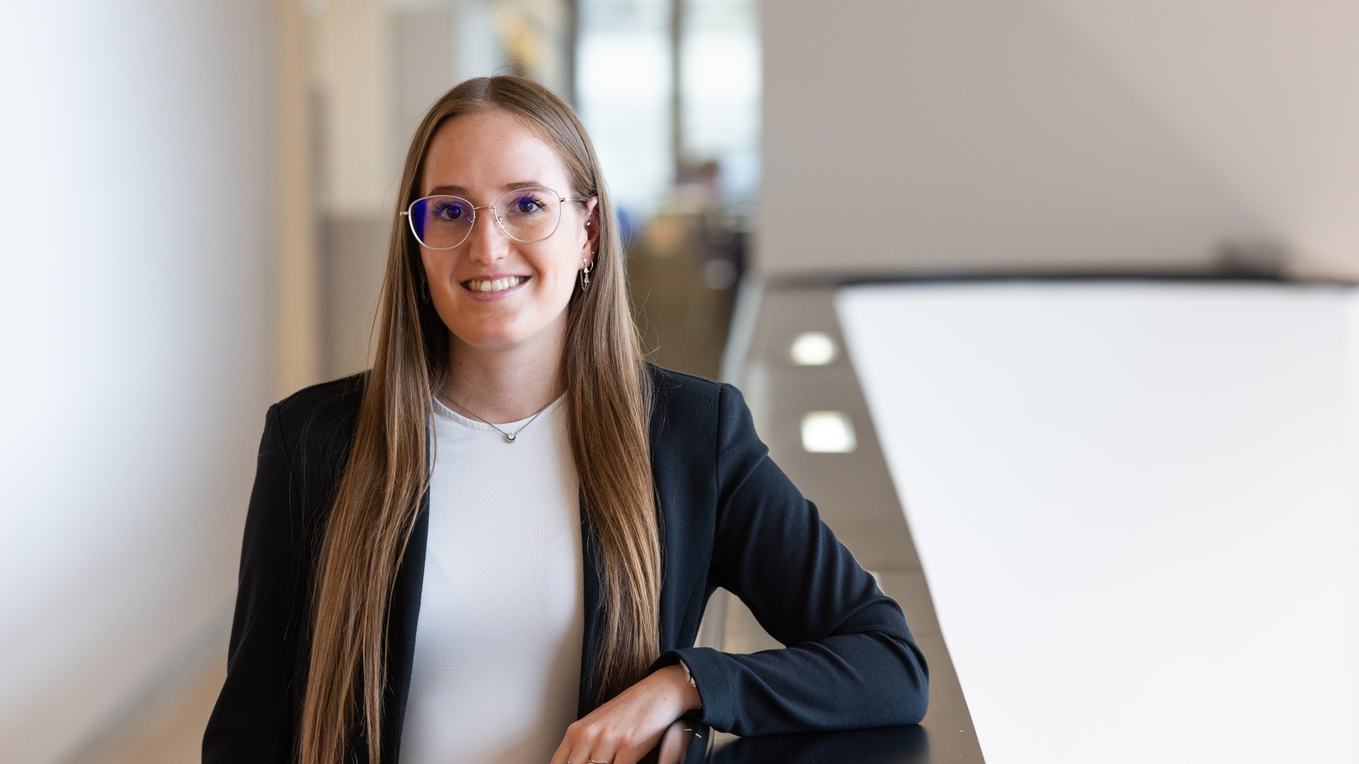Eine Frau mit Brille steht in einer Bankfiliale