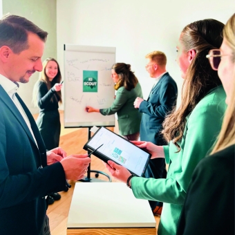 Personen die sich vor einem Flipchart unterhalten.