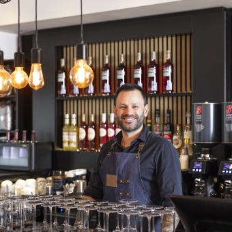 Ein Mann lächelt hinter einer Bartheke