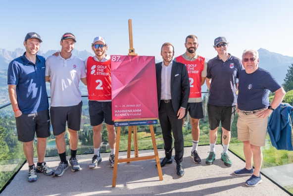 Bei der Präsentation des Hahnenkammposters für die Saison 2027 in Kitzbühel stehen mehrere Sportpersönlichkeiten gemeinsam vor dem neuen Plakat. Abgebildet sind: Fritz Dopfer (ehemaliger Alpinskifahrer), Alessandro Hämmerle (zweifacher Olympiasieger im Snowboardcross), Linus Strasser (deutscher Alpinskifahrer), Peter Kofler (BTV), Lukas Hinterseer (Fußballer), Huw Nightingale (britischer Snowboardcross-Olympiasieger) und Wilfried Leitzinger (Ehrenmitglied des Kitzbüheler Ski Clubs). Auf dem Poster ist der Schriftzug „18.–24. Jänner 2027 – Hahnenkammrennen Kitzbühel“ zu sehen.