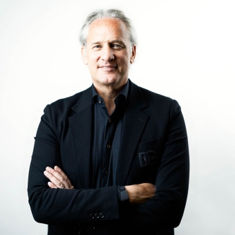 Porträtfoto von Mag. Martin Ohneberg, CEO der HENN Connector Group. Er blickt freundlich in die Kamera und trägt einen dunklen Anzug mit Hemd. Der Hintergrund ist neutral gehalten.