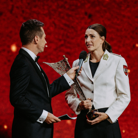 Skeletonpilotin Janine Flock wird auf einer Bühne im Rahmen der Auszeichnung zur „Österreichs Sportlerin des Jahres“ interviewt.