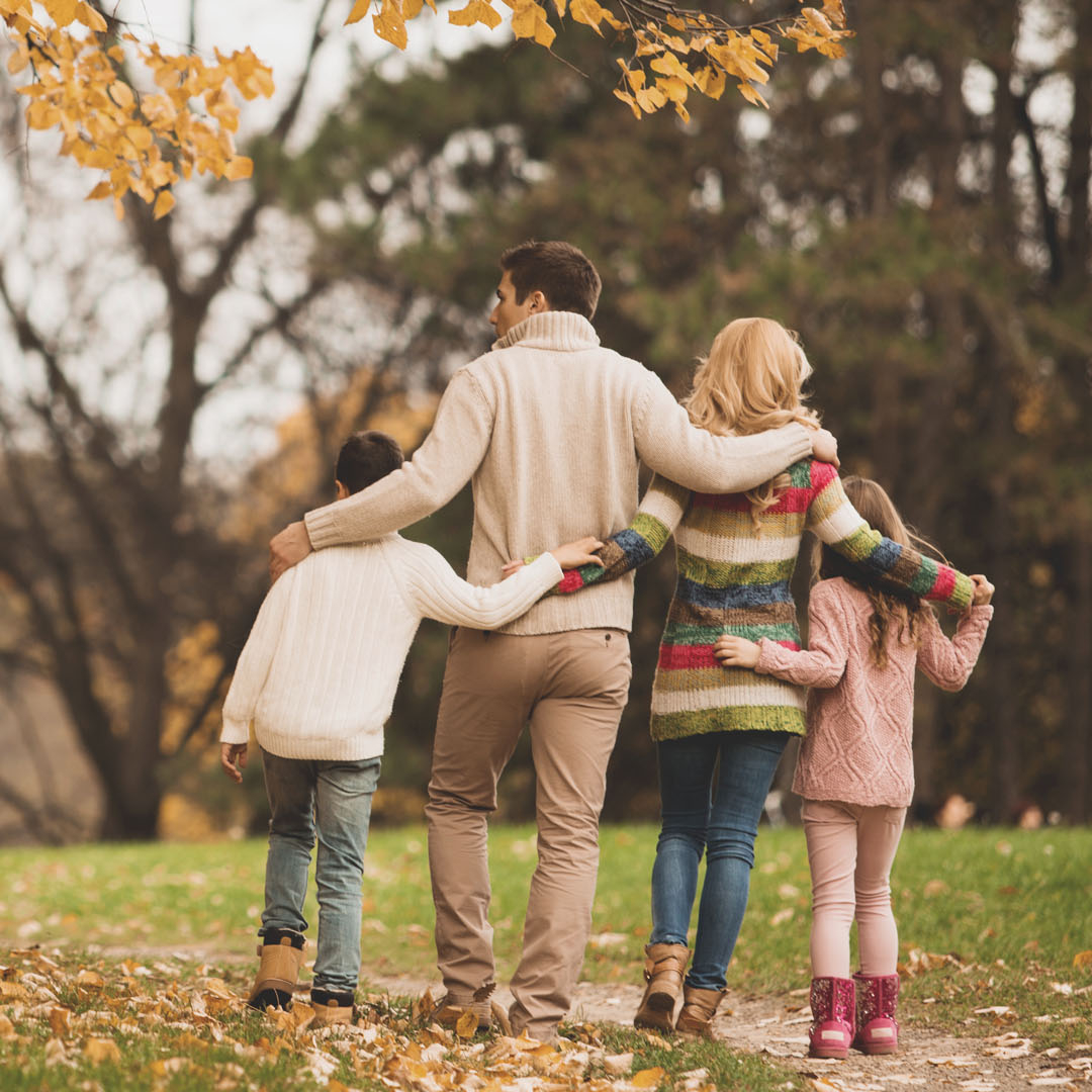 A family takes a walk in autumn in a park