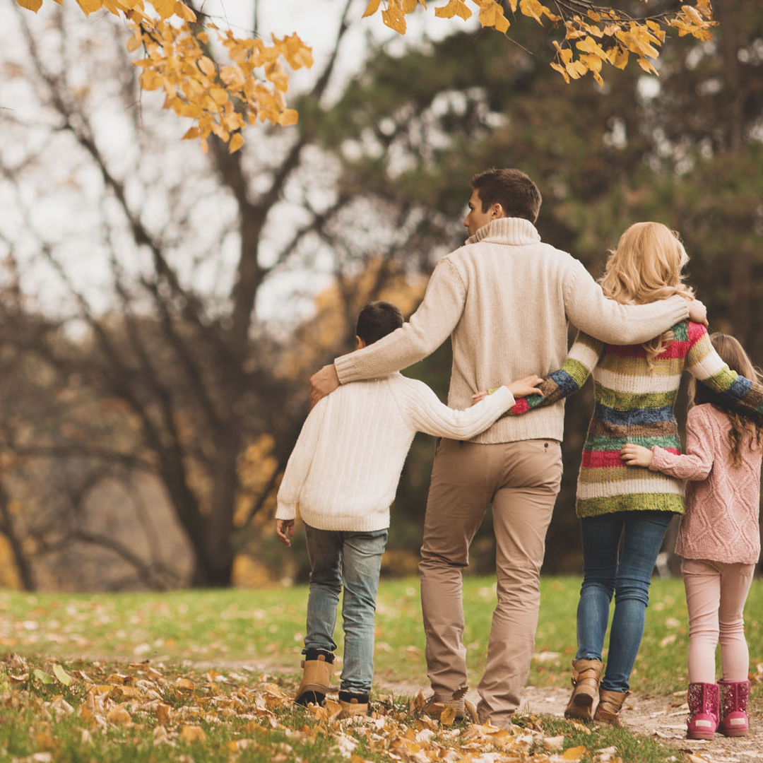 Eine Familie spaziert an einem schönen Herbsttag