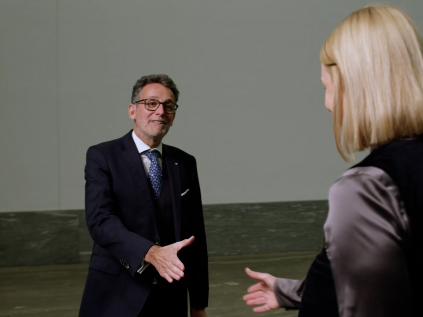 Gerhard Burtscher greets a customer with a handshake in the BTV Vier Länder Bank