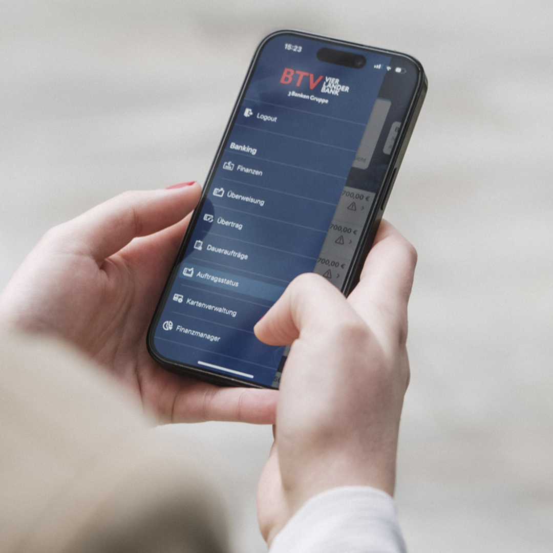 Eine Frau hält ihr Handy in der Hand und schaut in ihr Internetbanking.