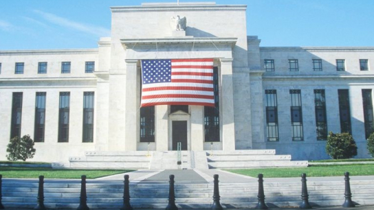 Gebäude mit der USA Flagge im Vordergrund.